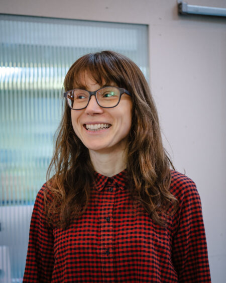 Ania Bas (c) Ashley Carr Headshot of Ania Bas, wearing glasses and smiling